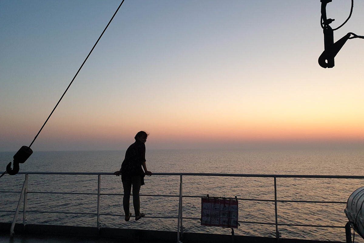 Girl looking out over Caspian Sea at sunset