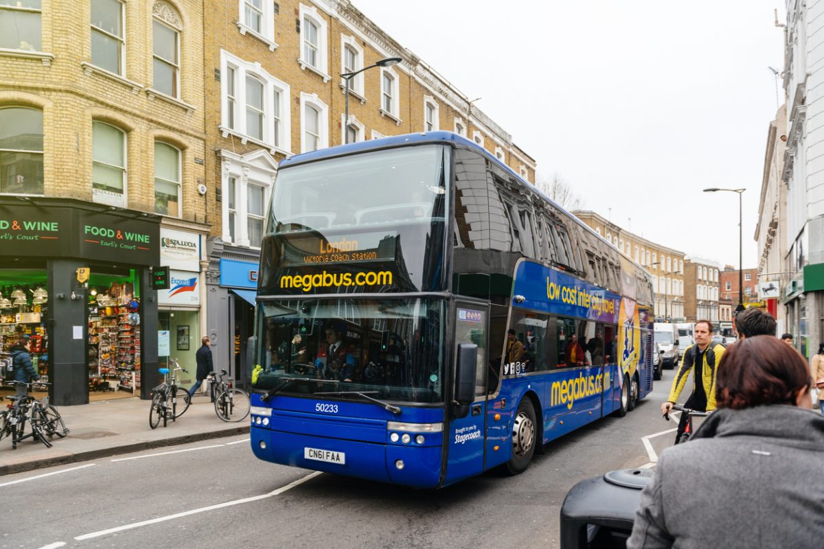 London: Morning rush on London street with double decker bluebus from MegaBus. Megabus is a low-cost coach service with services in Europe owned by Stagecoach Group