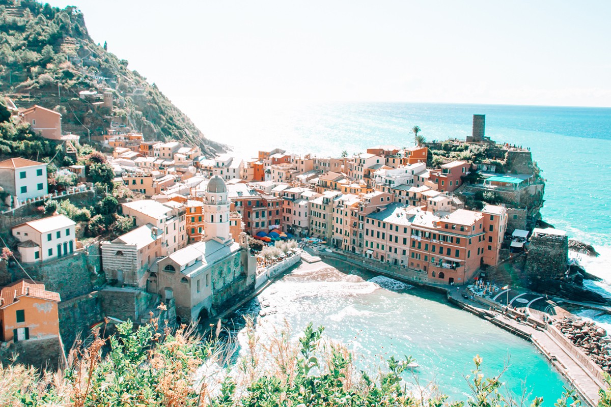 A shot of the colourful Cinque Terre villages from a train, against the backdrop of the blue sea