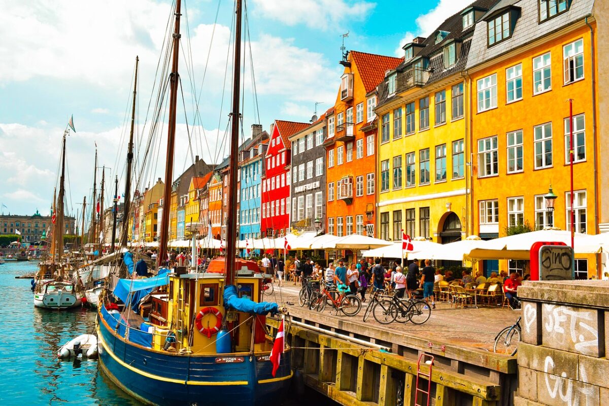 Brightly coloured houses along the canal in Copenhagen, which has boats bobbing on the water
