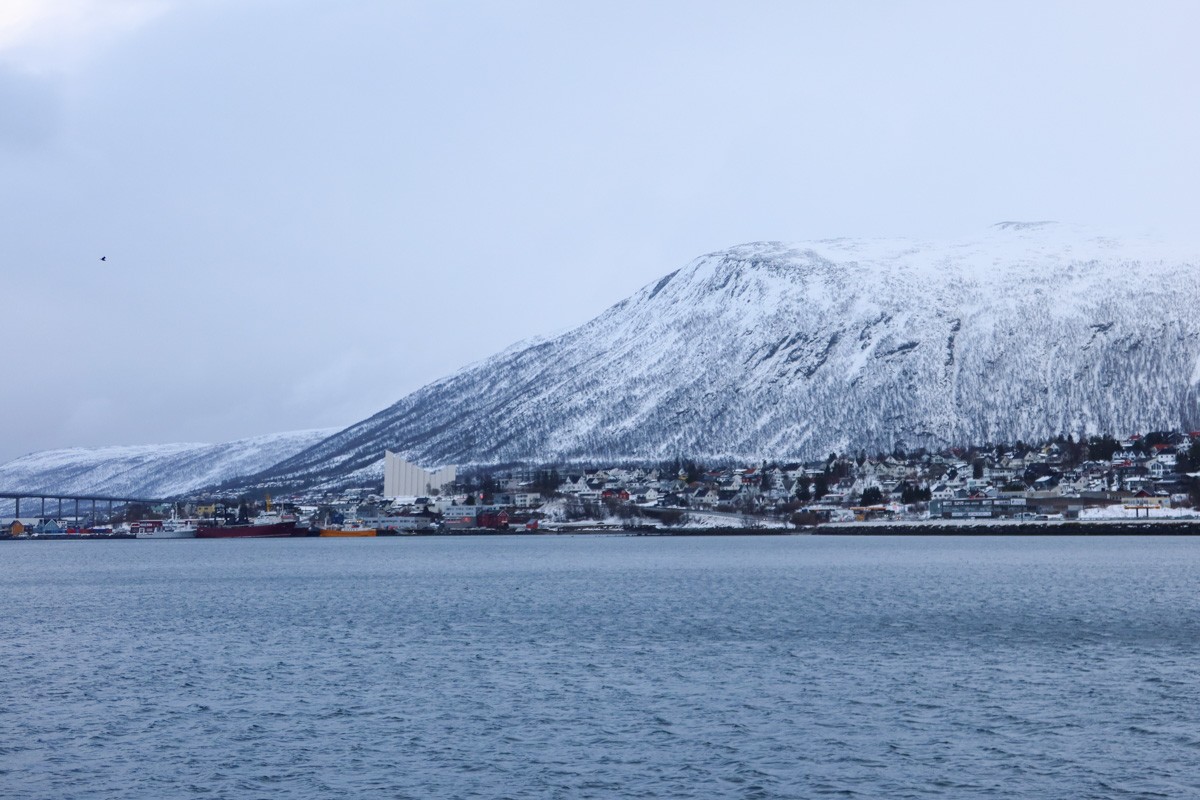 View of Tromso, overlooking the water with the Arctic Cathedral and snowy mountain in th ebackground