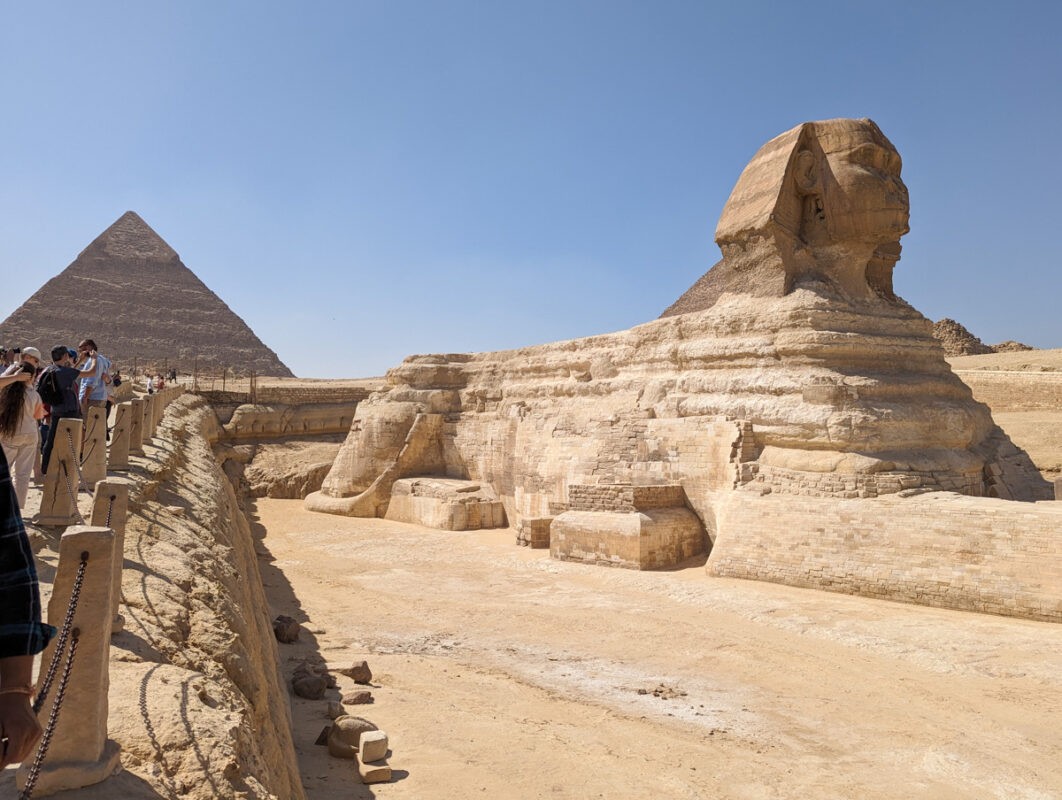 The Sphinx and a pyramid in the background, close to Giza in Cairo