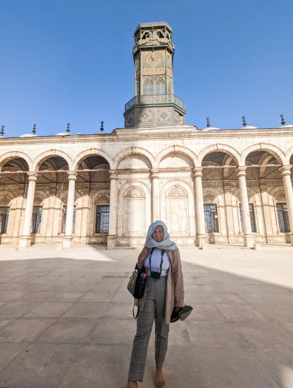 Girl standing infront of a mosque in Cairo, wearing a headscarf