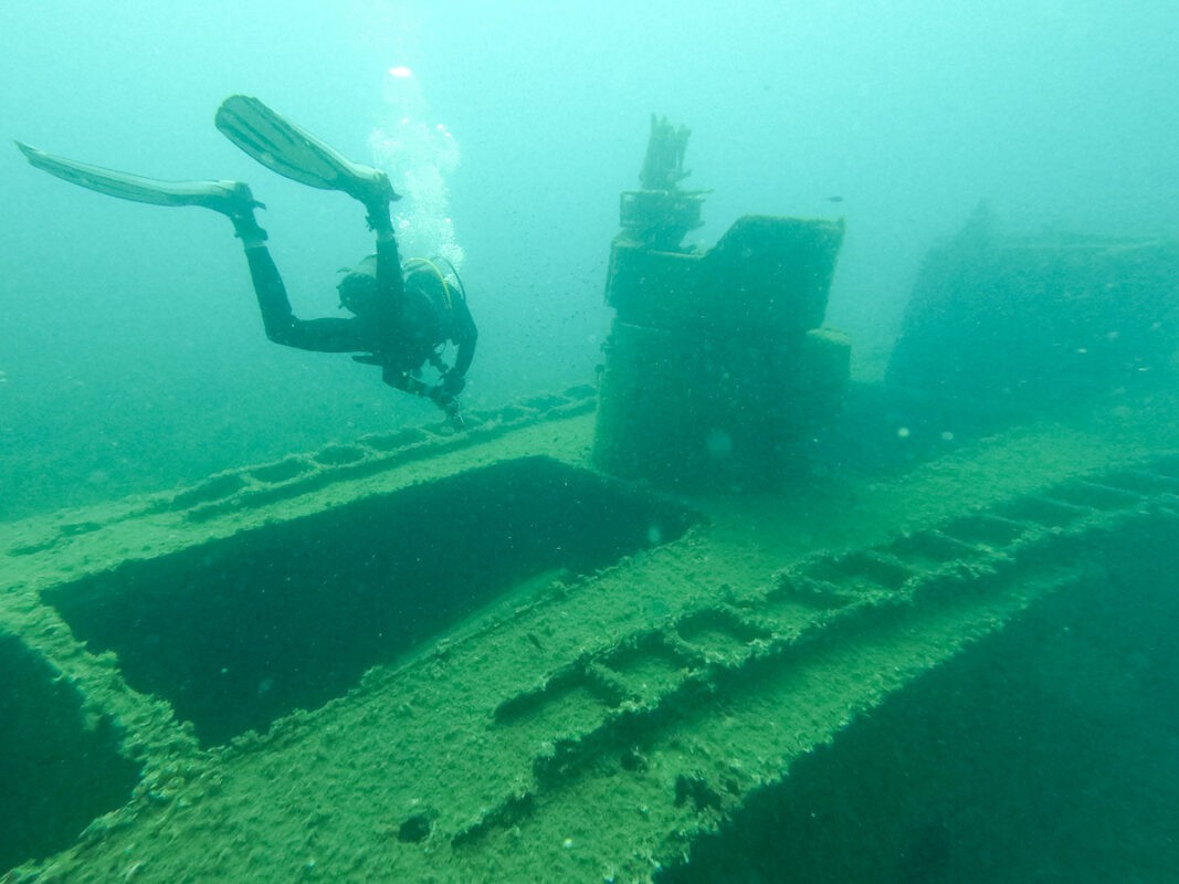 Scuba diving in Albania, a diver close the the wreck of a boat. 