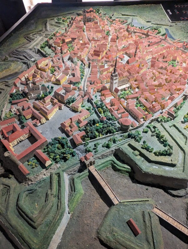 A detailed miniature model of Tallinn's old town, showcasing the dense arrangement of historical red-roofed buildings and narrow streets, highlighting the city's medieval architecture.