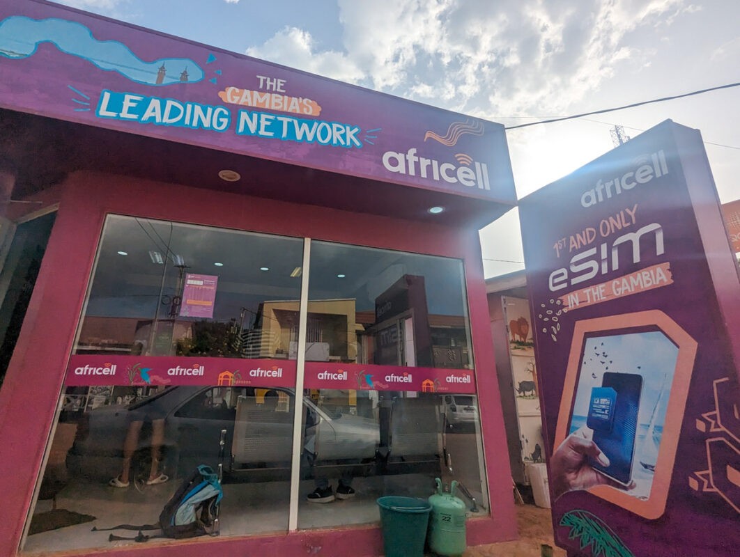 Exterior view of an Africell store in The Gambia, with signage promoting it as 'The Gambia's Leading Network' and advertising the '1st and only eSIM in The Gambia.