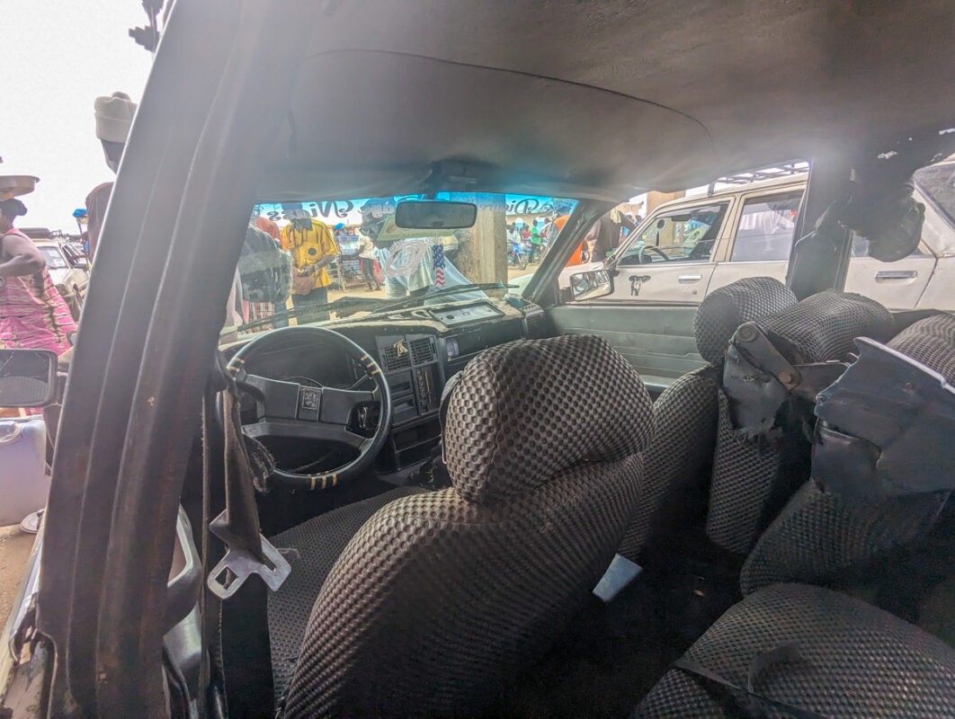 Inside view of a 'sept-places' vehicle showing the worn interior, indicative of its heavy usage in public transportation in Senegal.
