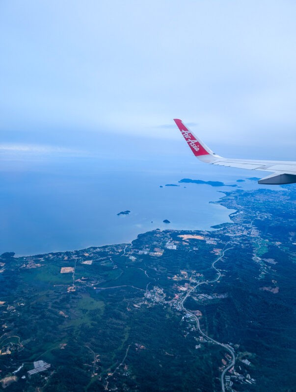 Aerial view from an AirAsia plane wing showing the coastline and landscapes of Malaysian Borneo.